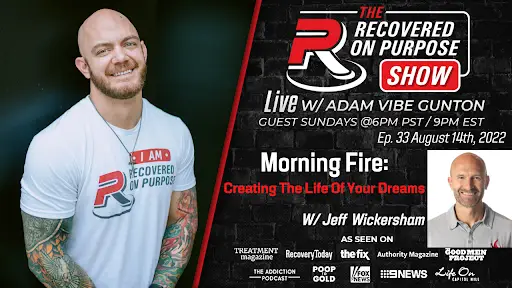 A smiling, tattooed man in a white "Recovered On Purpose" shirt stands beside a promotional poster for "The Recovered On Purpose Show" with Adam Vibe Gunton, featuring "Morning Fire: Creating the Life of Your Dreams" with Jeff Wickersham. The poster includes logos of featured media appearances and airs episode 33 on August 14th, 2022.