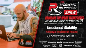 Bald man with tattoos typing on a laptop outdoors. Text promotes "Recovered On Purpose Show," focusing on "Emotional Stability" in the Book of Psalms.