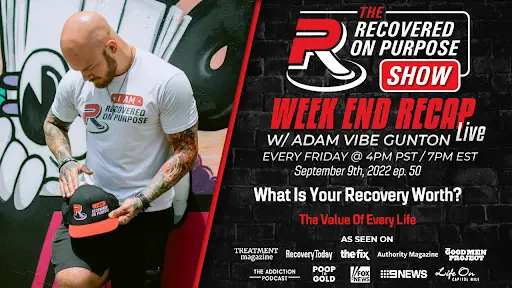 A man with tattoos sits beside a large advertisement for "The Recovered On Purpose Show." The event details and media logos are displayed, promoting a live recap on September 9th, 2022, focused on recovery and life's value.