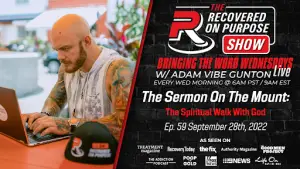 Bald man with tattoos focused on a laptop at a table with a "Recovered On Purpose" cap. Text promotes a live show on faith and recovery.