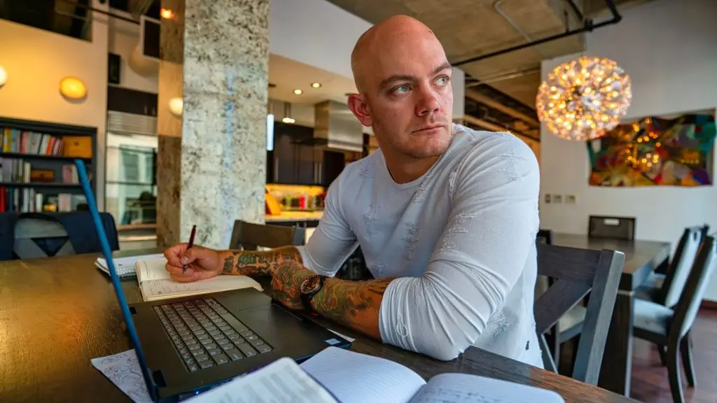 The author of Relapse Prevention Strategies For Addicts In Early Recovery at his desk writing in his journal