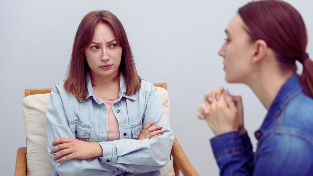 Two women having a serious face-to-face conversation about accountability and repair.